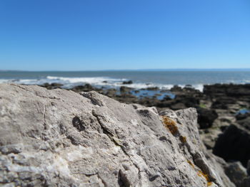 Rock formation on beach against clear blue sky