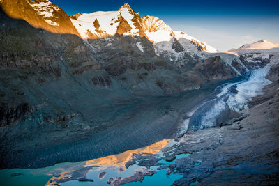 Scenic view of snowcapped mountains against sky at morning