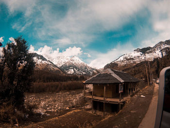 Houses on snowcapped mountain against sky