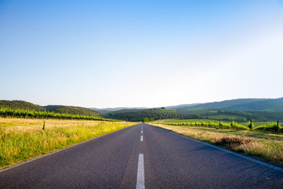 Road passing through land against clear sky