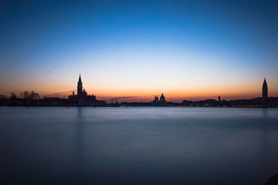 View of mosque and buildings against sky during sunset