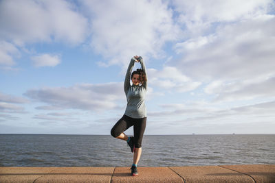 Woman practicing yoga near the sea.