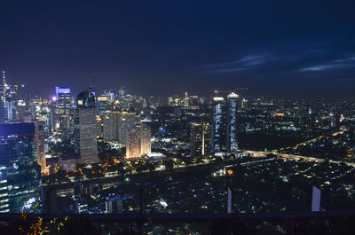 Illuminated cityscape against sky at night