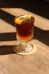 Midsection of woman holding drink on table