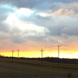 View of road against cloudy sky at sunset