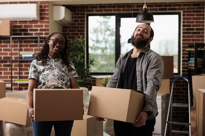 Couple holding boxes at home