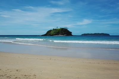 Scenic view of beach against blue sky