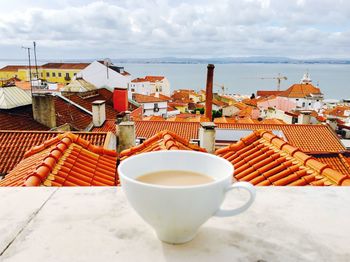 Tea cup by sea against sky