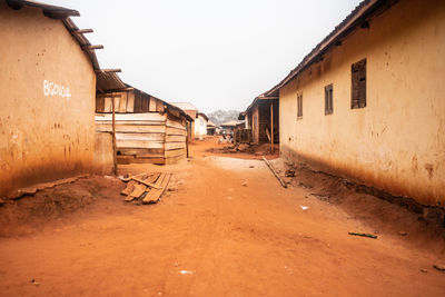 Empty alley amidst buildings against clear sky