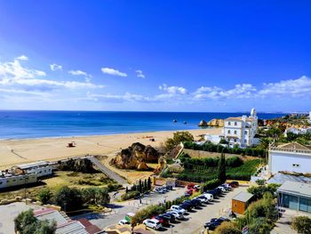 High angle view of buildings and sea against blue sky