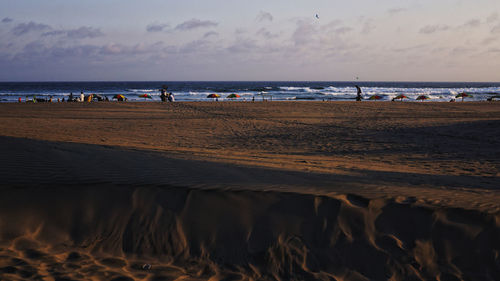 Scenic view of beach against sky during sunset