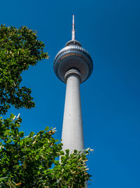 Low angle view of communications tower against blue sky