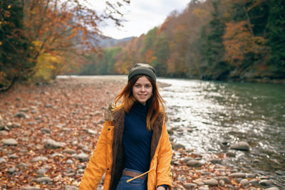 Portrait of smiling young woman standing on land during autumn