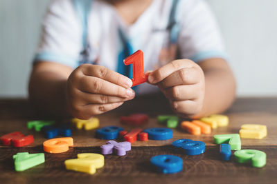 Close-up of hand holding toys on table