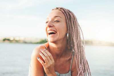 Happy young woman against sky