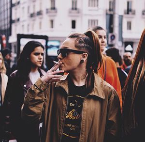 Young man smoking cigarette in city