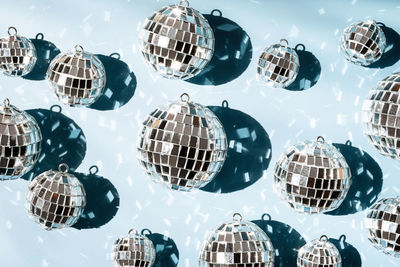 Shiny mirrored disco balls casting reflections and creating festive atmosphere.