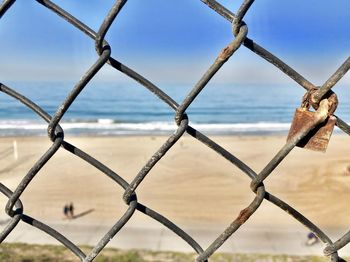 Close-up of chainlink fence against sky