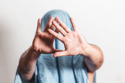 Man showing stop gesture with his face hidden