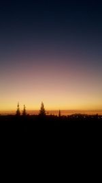 Silhouette landscape against clear sky during sunset