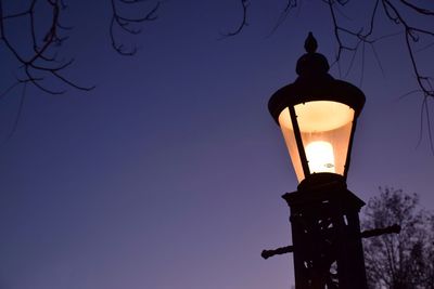 Low angle view of illuminated street light against blue sky