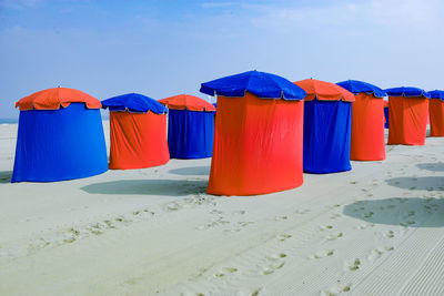 Multi colored umbrellas on beach against clear blue sky