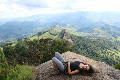 High angle view of woman lying on rock