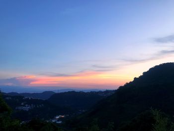 Scenic view of silhouette mountains against sky at sunset