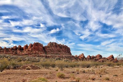 Rock formations on landscape against cloudy sky