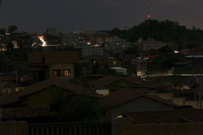 Illuminated cityscape against sky at night