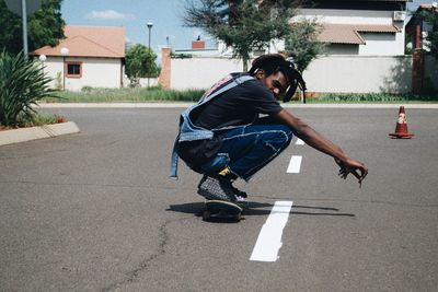 Side view of man skating on road