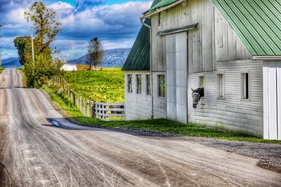 Road by building against sky