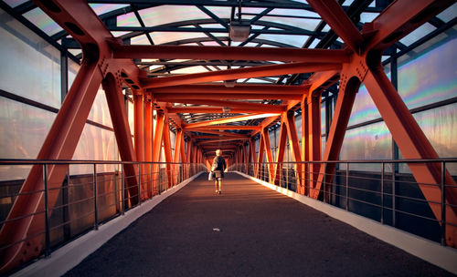 Rear view of people walking on footbridge