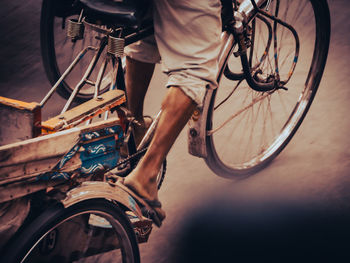 Low section of man riding bicycle on street