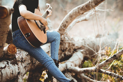 Man playing guitar on tree