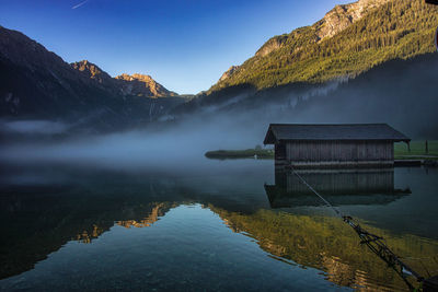 Scenic view of lake by mountain against sky