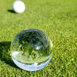 Close-up of crystal ball on grass