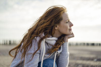 Redheaded woman enjoying fresh air at the beach