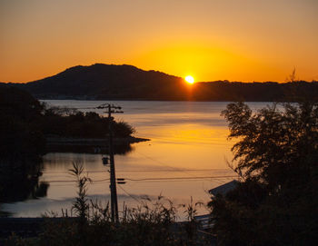 Scenic view of lake against orange sky