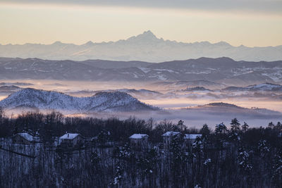 Scenic view of snowcapped mountains against sky during sunset