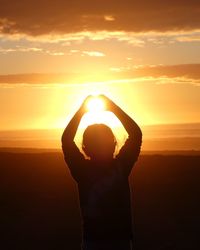 Silhouette girl standing at sunset