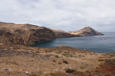 Scenic view of sea and mountains against sky