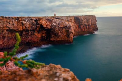 Rock formations by sea against sky