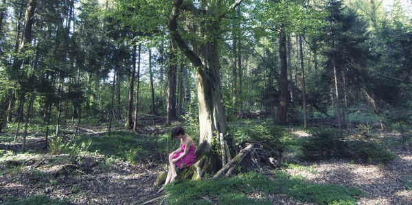 Woman amidst trees in forest