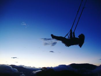 Low angle view of person paragliding over mountain