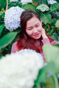 Mid adult woman by flowering plants in park