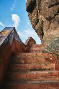 Low angle view of steps against cloudy sky