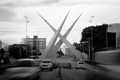 Cars on street in city against sky