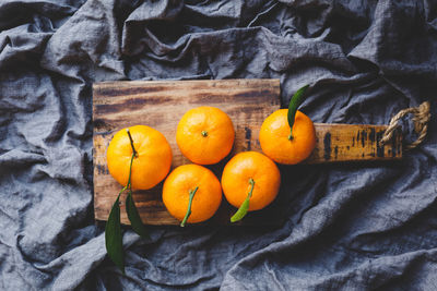 Directly above view of oranges on cutting board over fabric