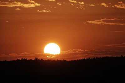 Scenic view of silhouette landscape against orange sky